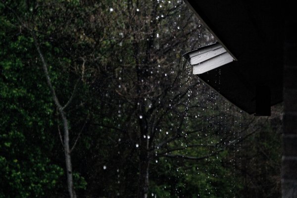 heavy rain falling off a roof at night